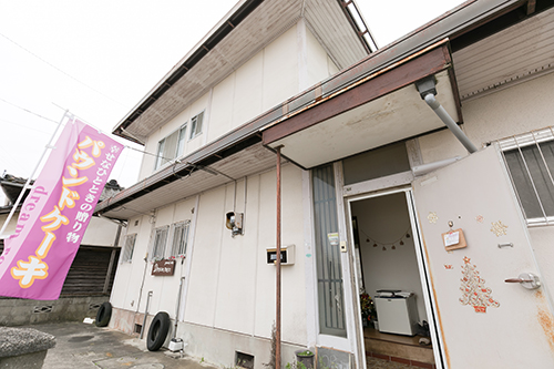 紫ののぼりがある建物がお店です。